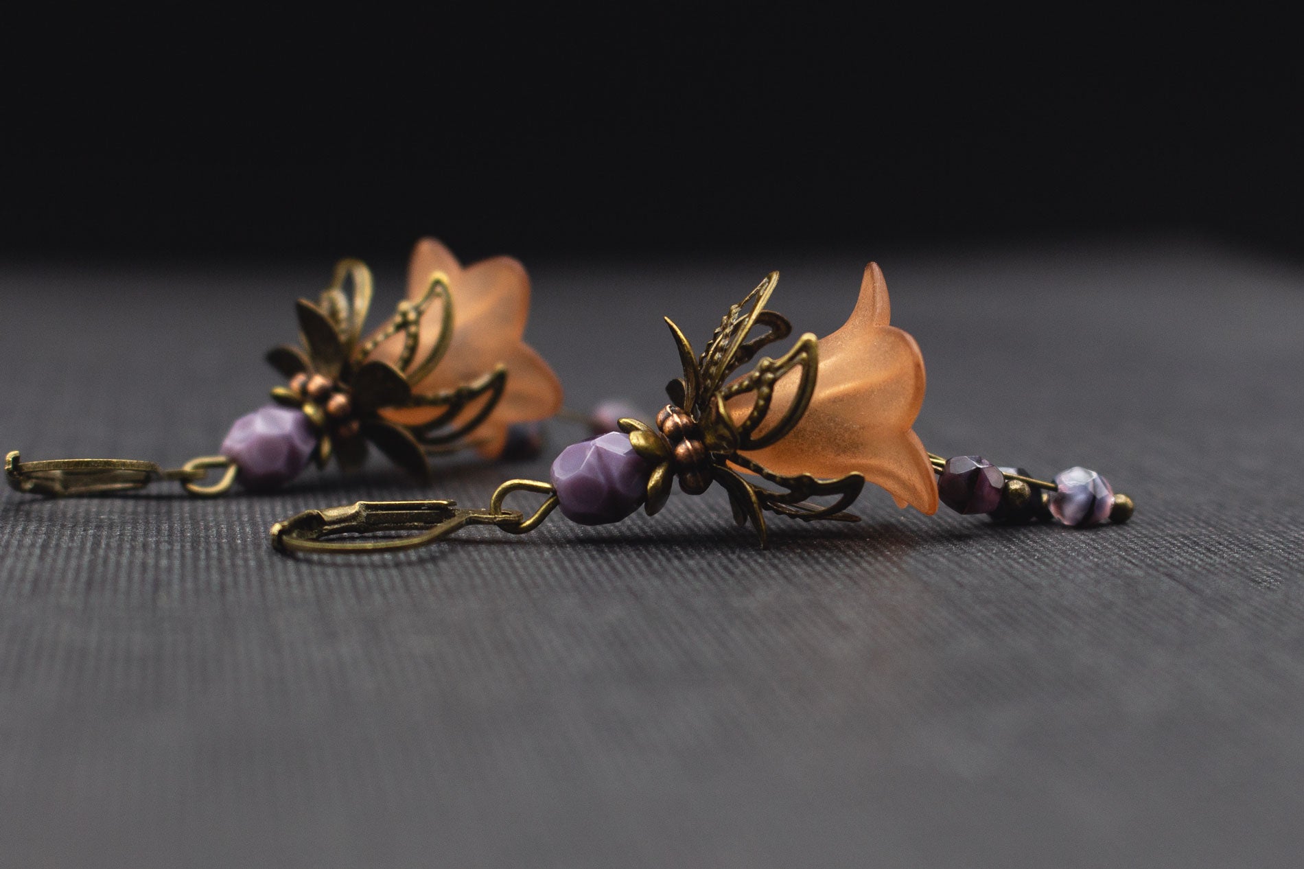 Detailaufnahme von Boho-Ohrringen mit braunen Blüten und fliederfarbenen Glasperlen