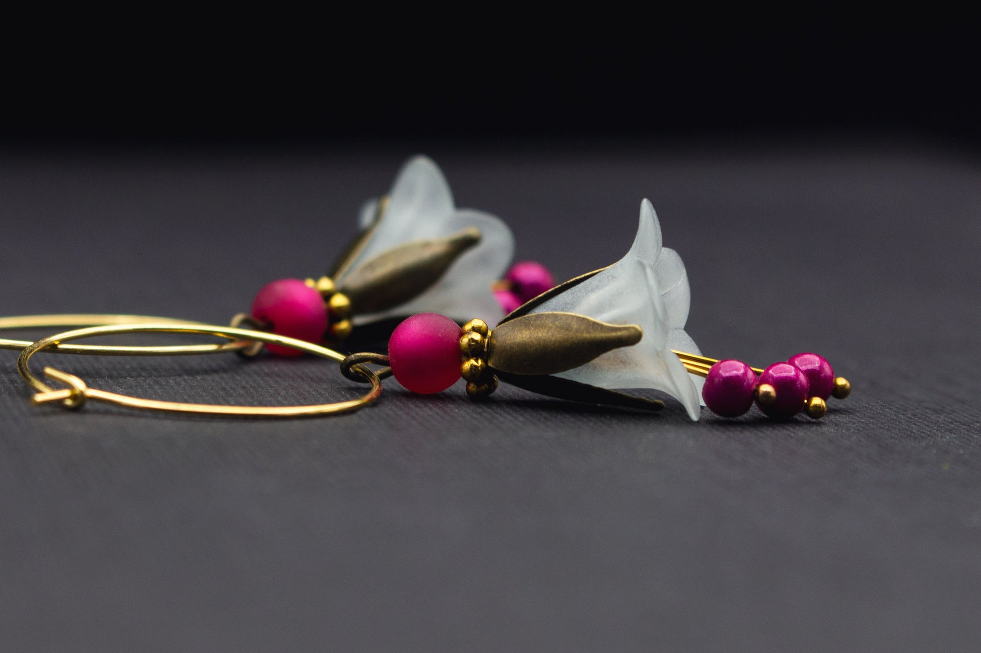 Seitenansicht Creolen mit Blüten in Eisblau und Pink, goldfarbene Details