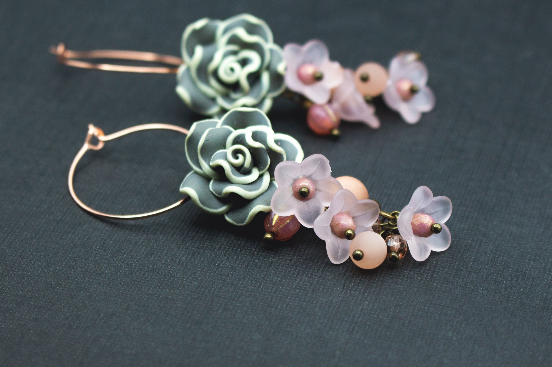 Detailaufnahme von Creolen mit Fimo- und Acrylblüten in Roségold, Grau und Rosa