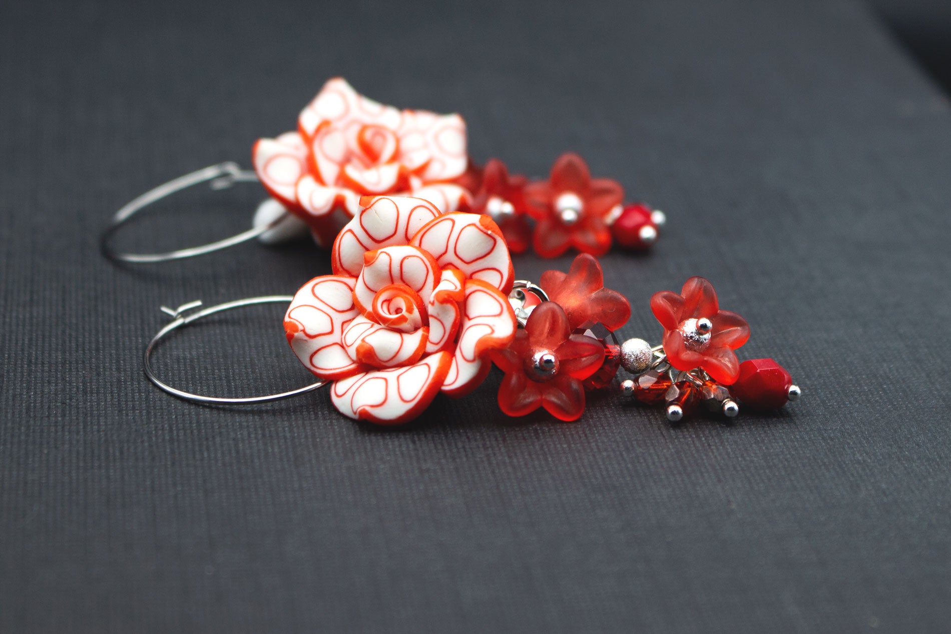 Detail goldfarbene Creolen mit Fimo-Blüten in Rot-Weiß und roten Glasperlen