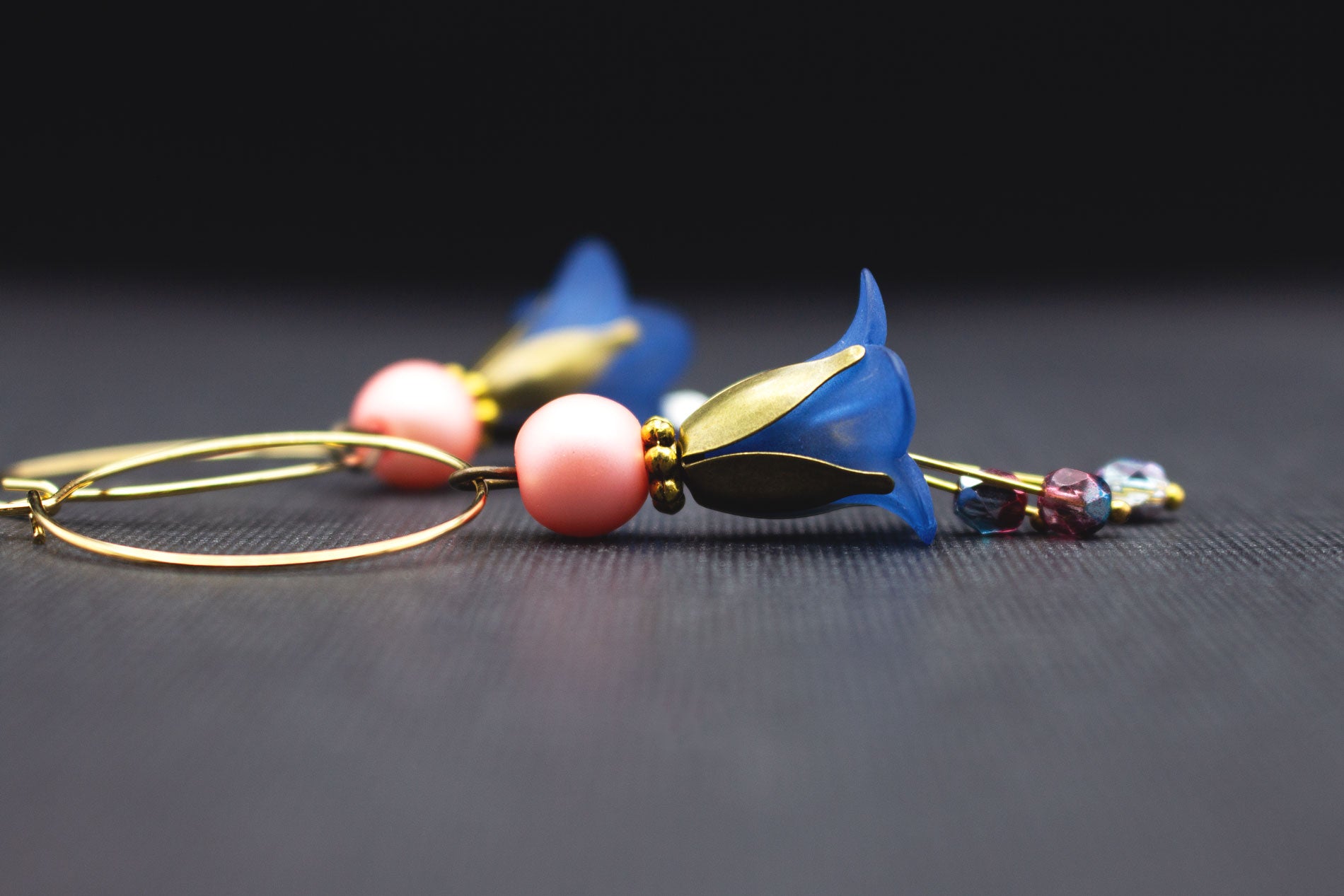 Goldfarbene Creolen mit dunkelblauen Blüten und rosa Glasperlen
