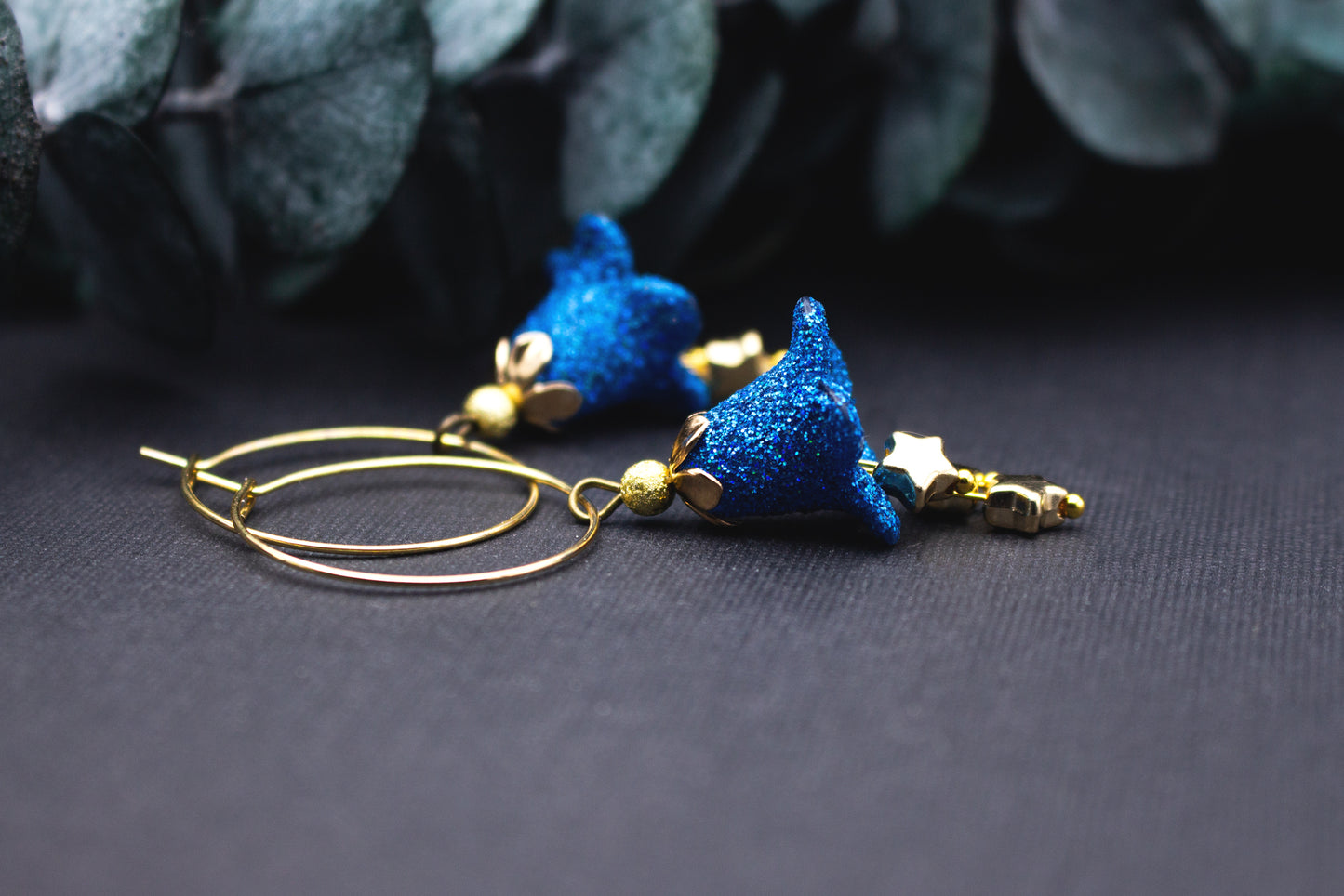 Funkelnde Creolen Ohrringe blau und gold mit Sternenanhänger und Glitzereffekt