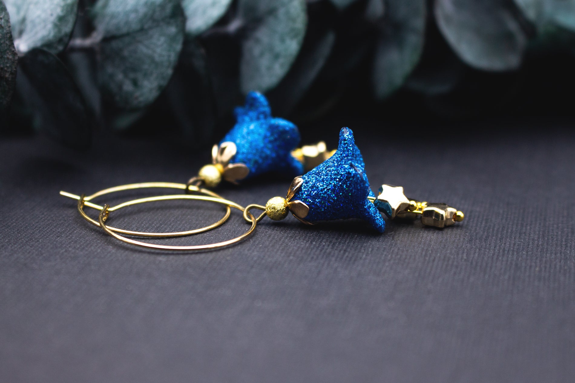Funkelnde Creolen Ohrringe blau und gold mit Sternenanhänger und Glitzereffekt