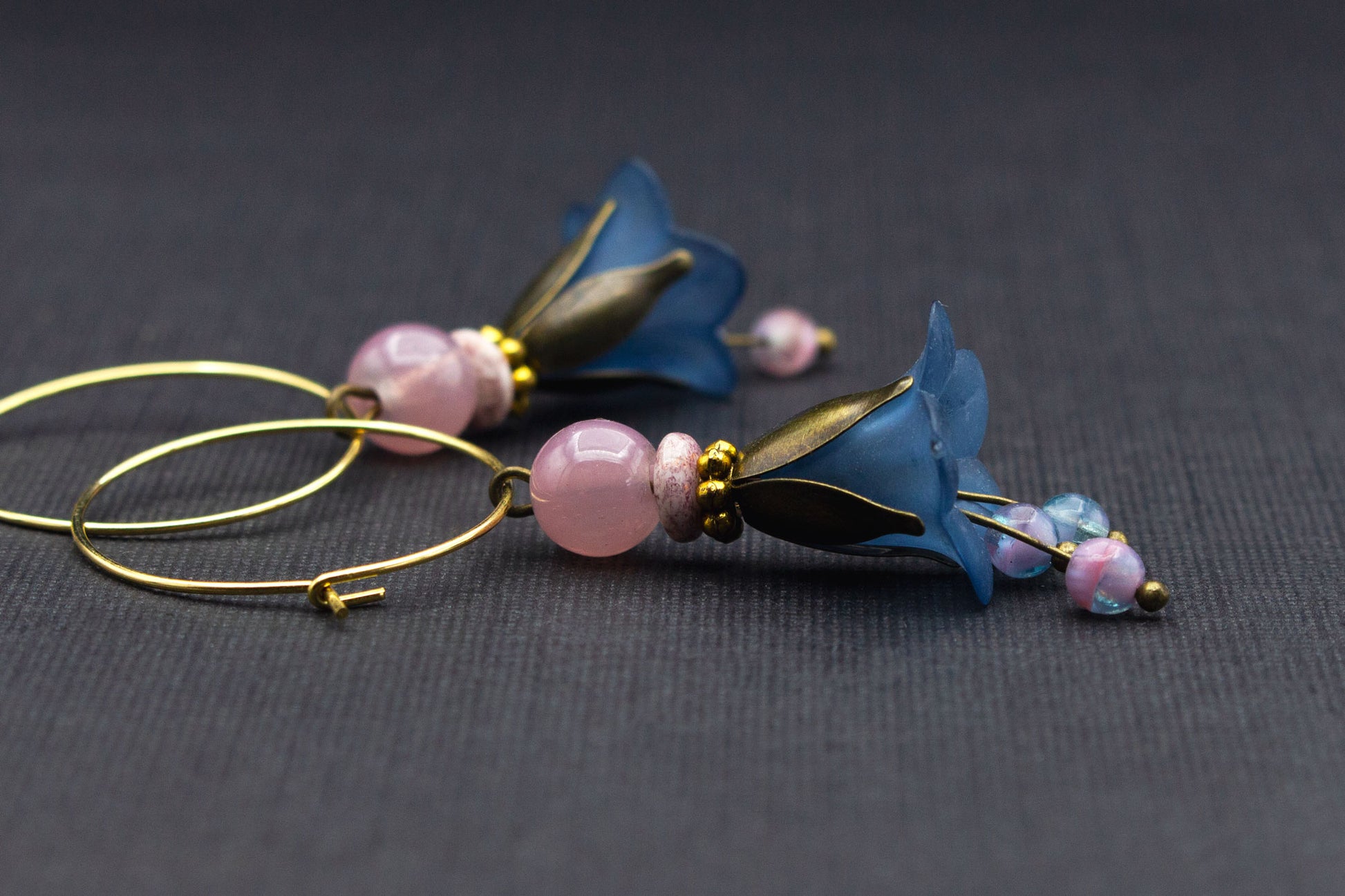 Seitenansicht goldfarbener Creolen mit Rauchblau-Blüten und rosa Perlen