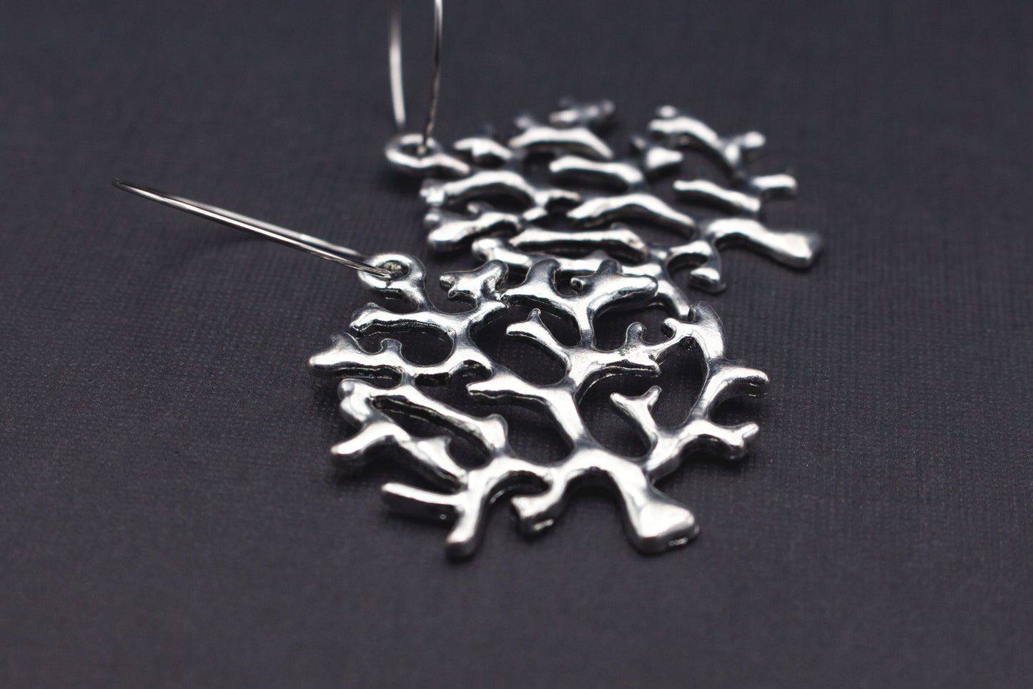 Detailansicht silberfarbene Creolen mit Baum-Anhänger, elegantes Schmuckdesign für Alltag und besondere Anlässe