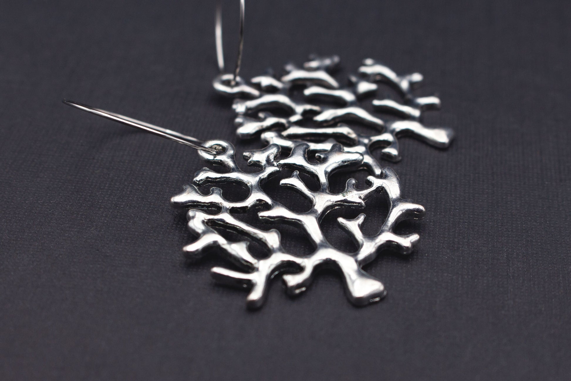 Detailansicht silberfarbene Creolen mit Baum-Anhänger, elegantes Schmuckdesign für Alltag und besondere Anlässe