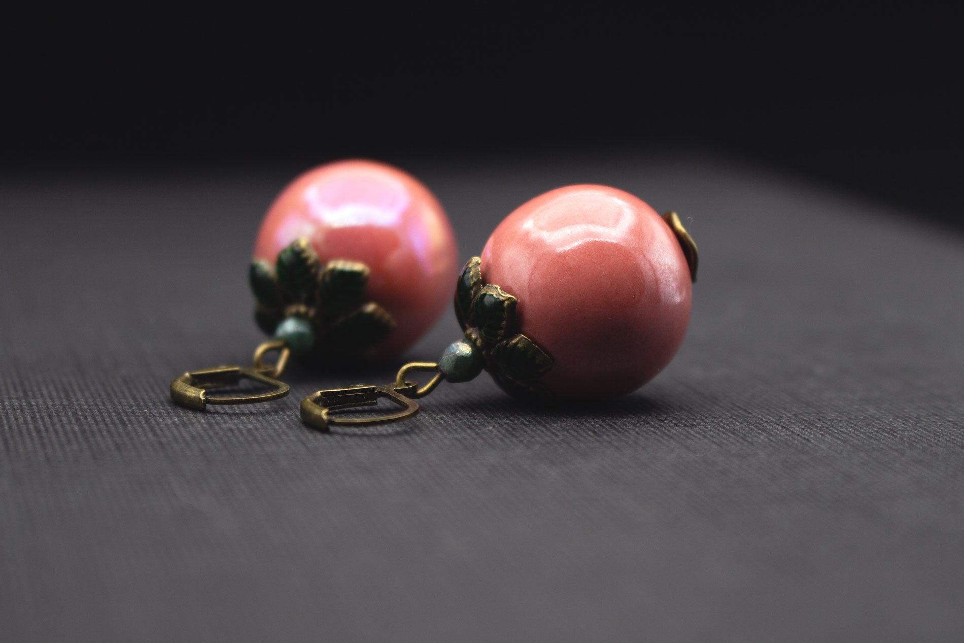 Detailansicht roséfarbene Keramikperlen Ohrringe mit dunkelgrünen Blattperlkappen, elegante Handarbeit