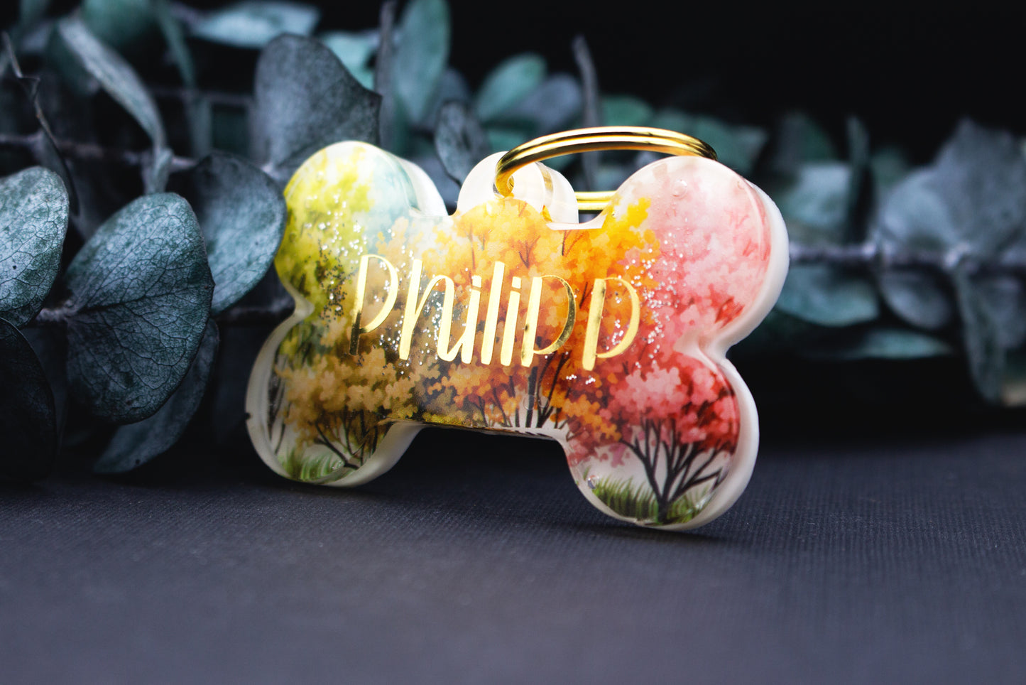 Detailaufnahme der Hundemarke FARBENWALD mit Waldmotiv, Farbverlauf und glänzender Resin-Oberfläche, personalisierbar