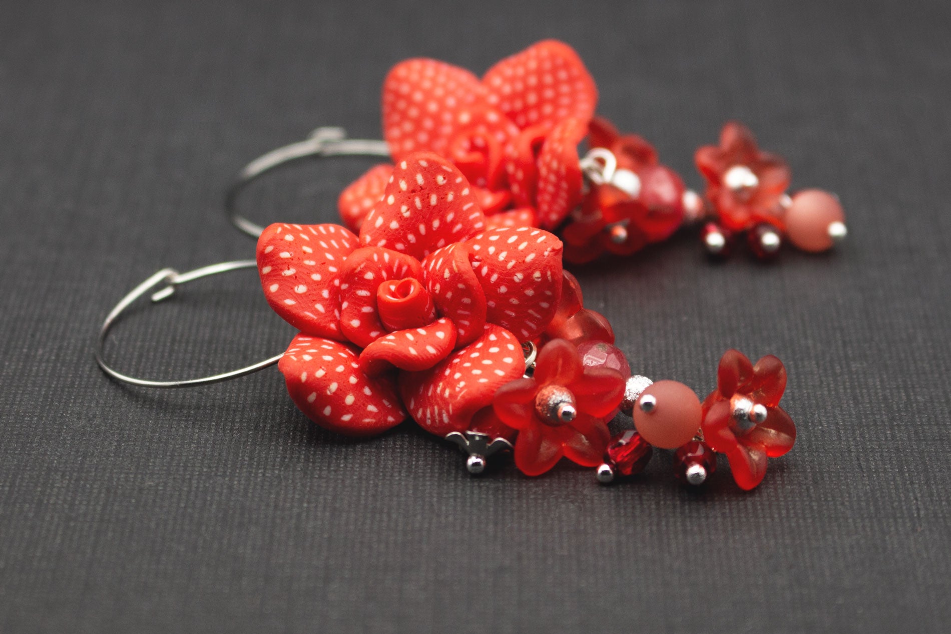 Seitenansicht von roten Fimo-Blütenohrringen mit Acrylblüten und Glasperlen