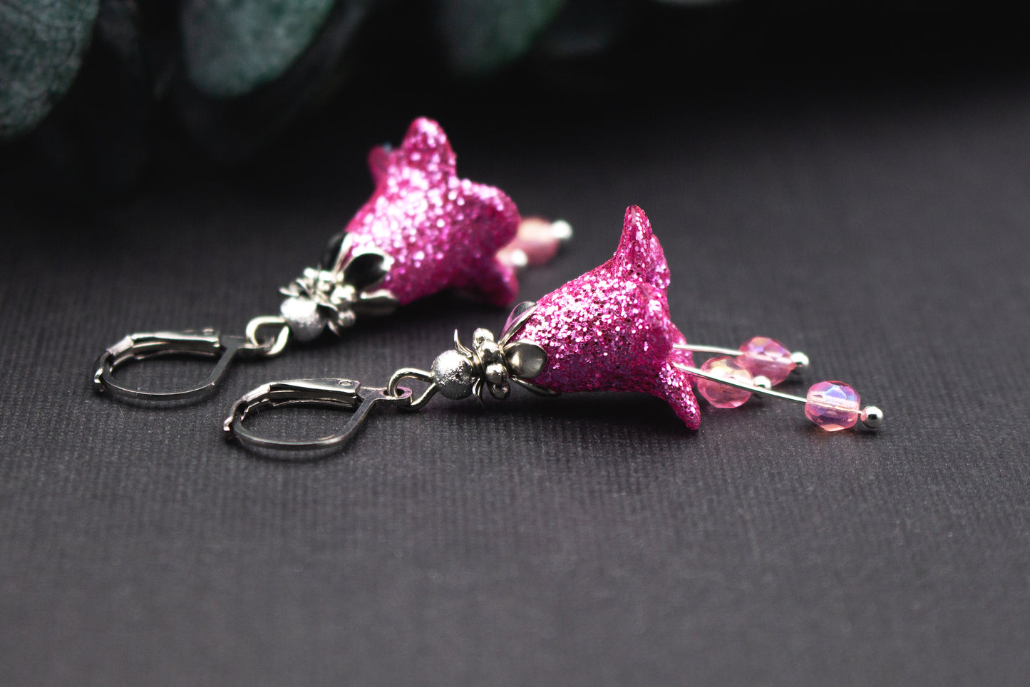 Detailansicht einer pinken Glitzerblüte an silberfarbener Klappbrisur mit zarten Glasperlen