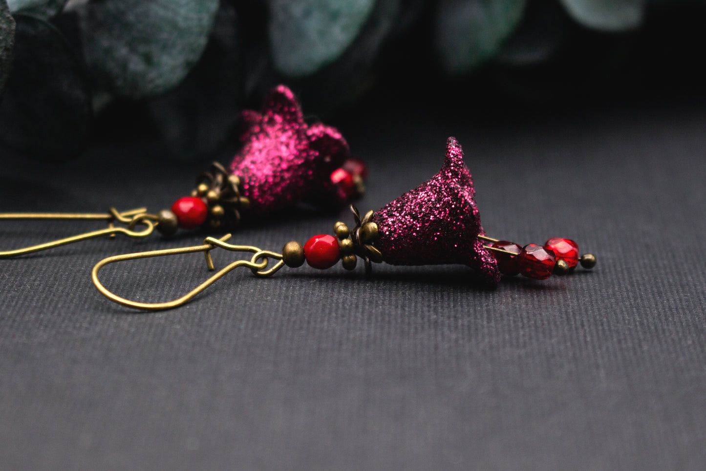 Ausdrucksstarke Glitzer Ohrringe mit Blüten und Glasperlen in warmen Rot- und Beerentönen