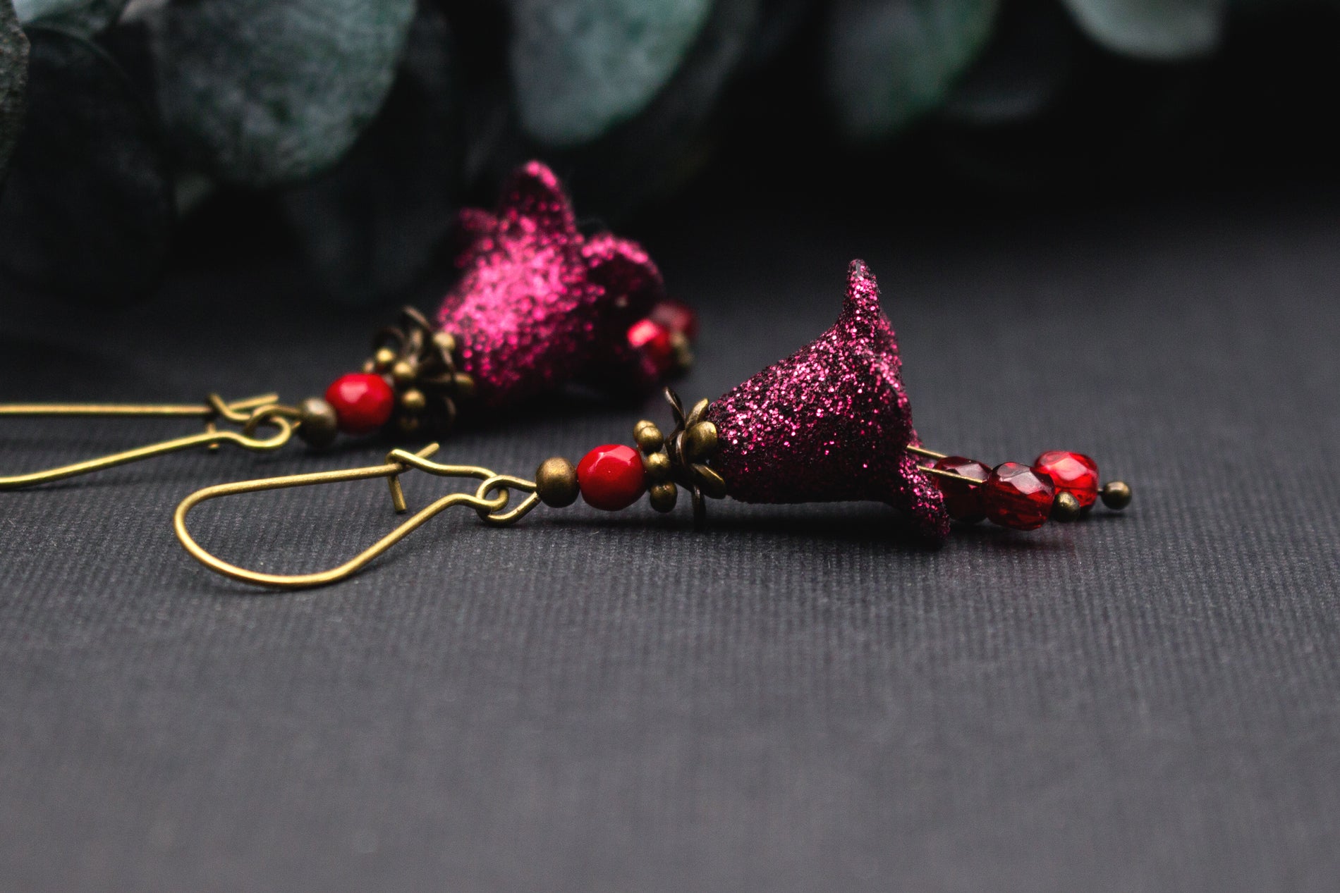 Ausdrucksstarke Glitzer Ohrringe mit Blüten und Glasperlen in warmen Rot- und Beerentönen