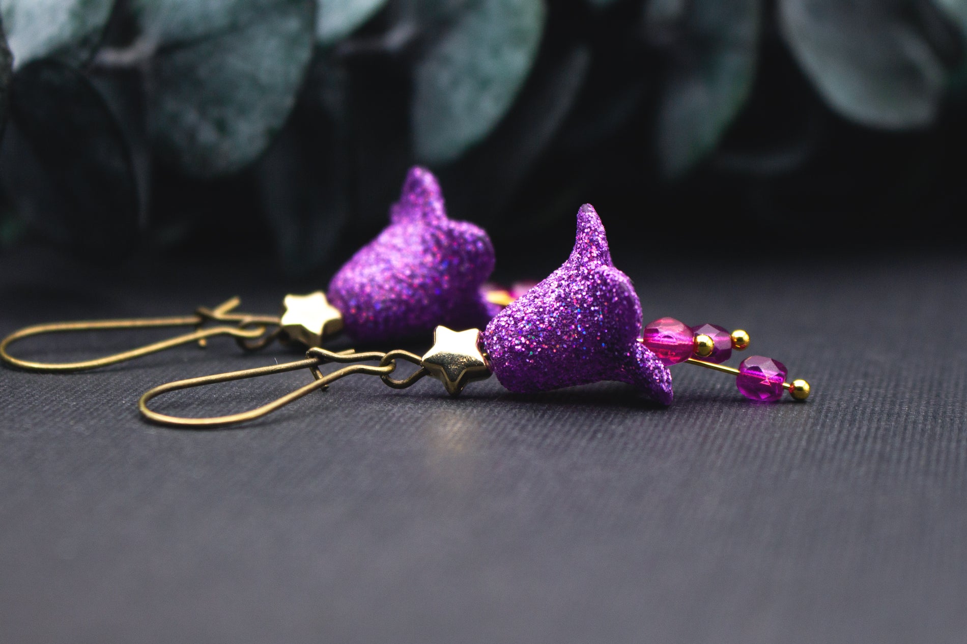 Detailansicht einer lila Glitzerblüte mit feinem Schimmer und goldfarbenem Stern