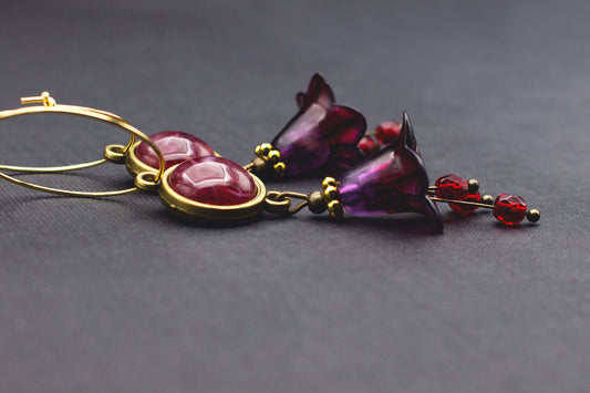 Goldene Creolen mit dunkelrotem Cabochon, lila Blüten und roten Glasperlen