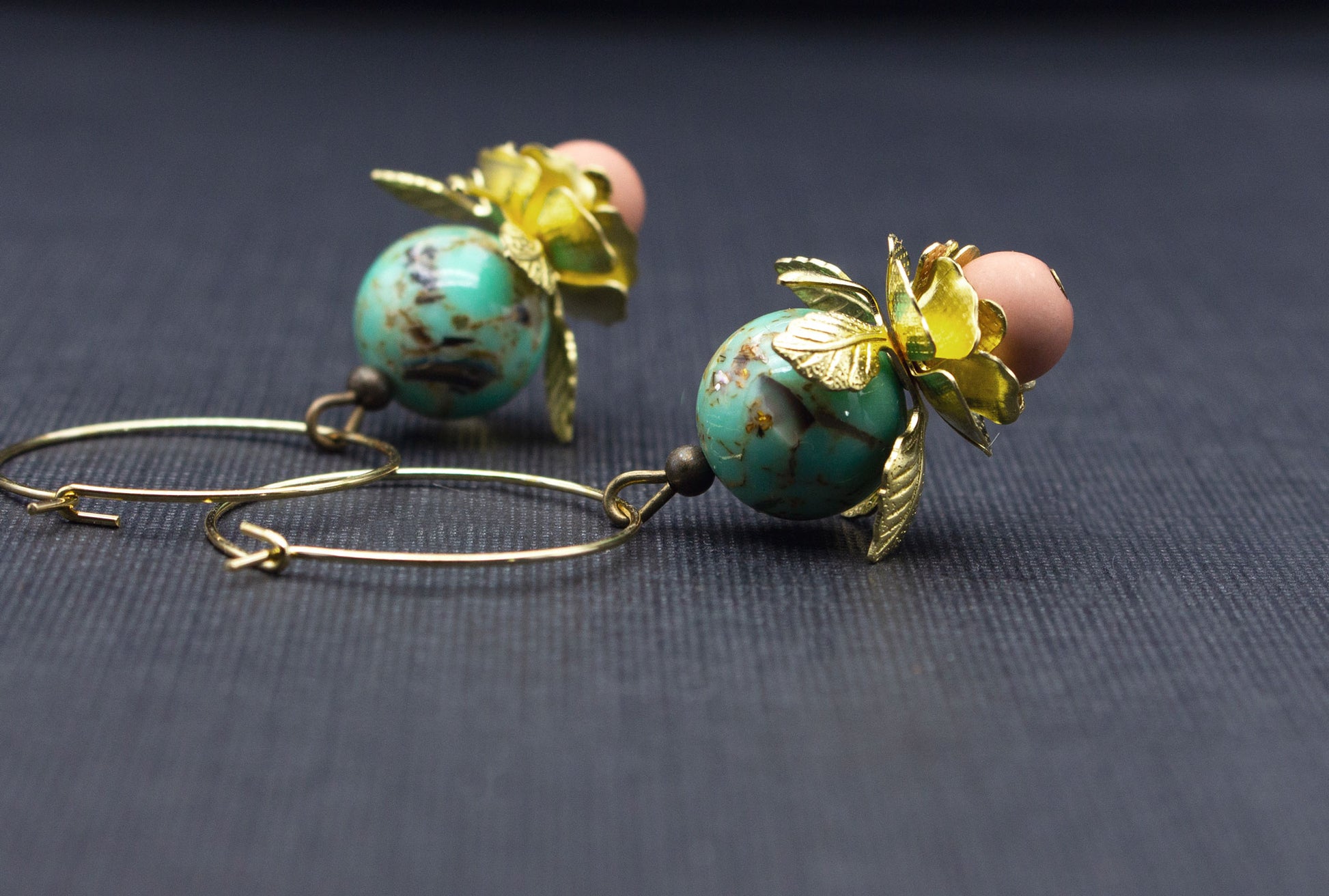 Seitenansicht goldene Creolen mit Metallblüten und mintfarbenen Glasperlen