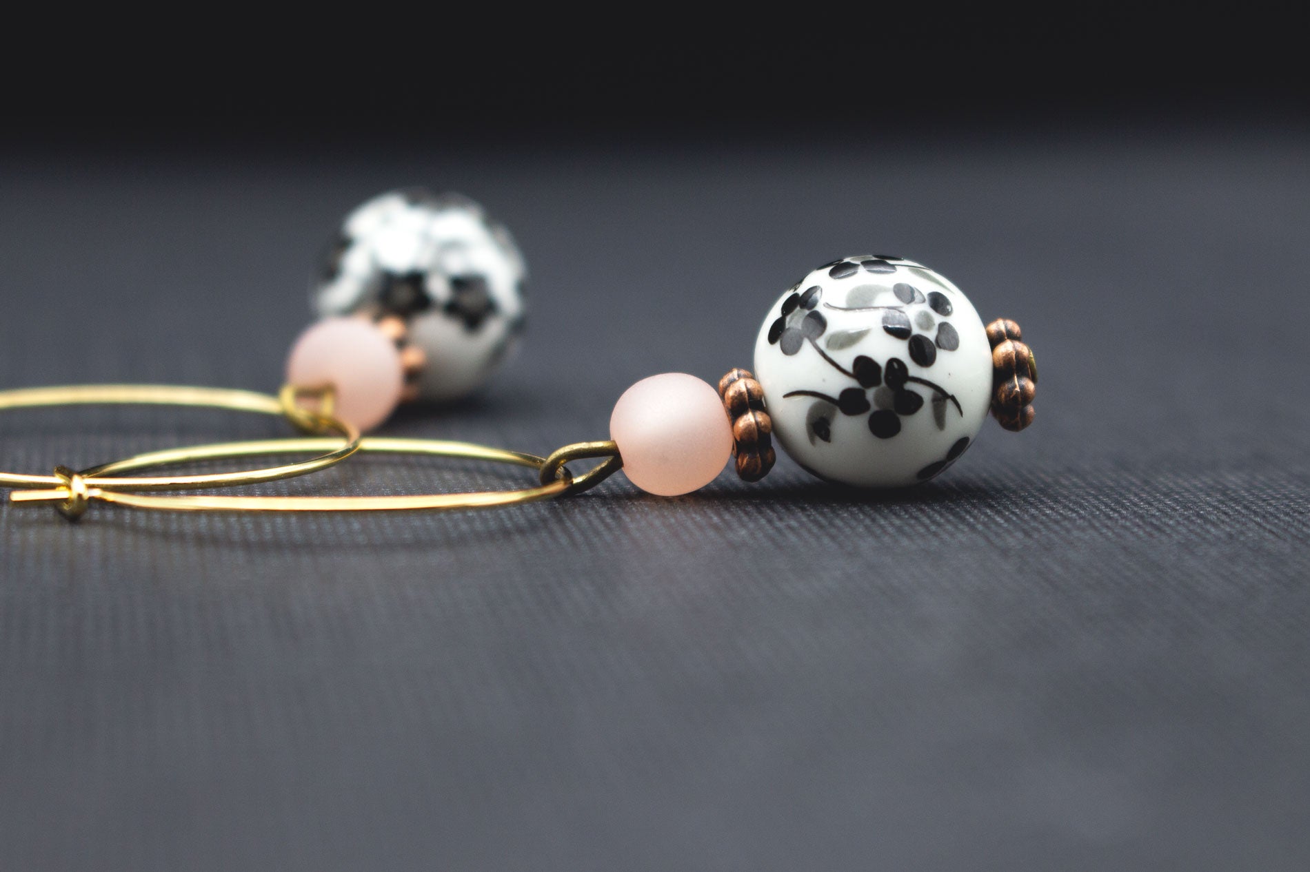 Detail goldfarbene Creolen mit Kirschblütenmotiv und rosa Polarisperle