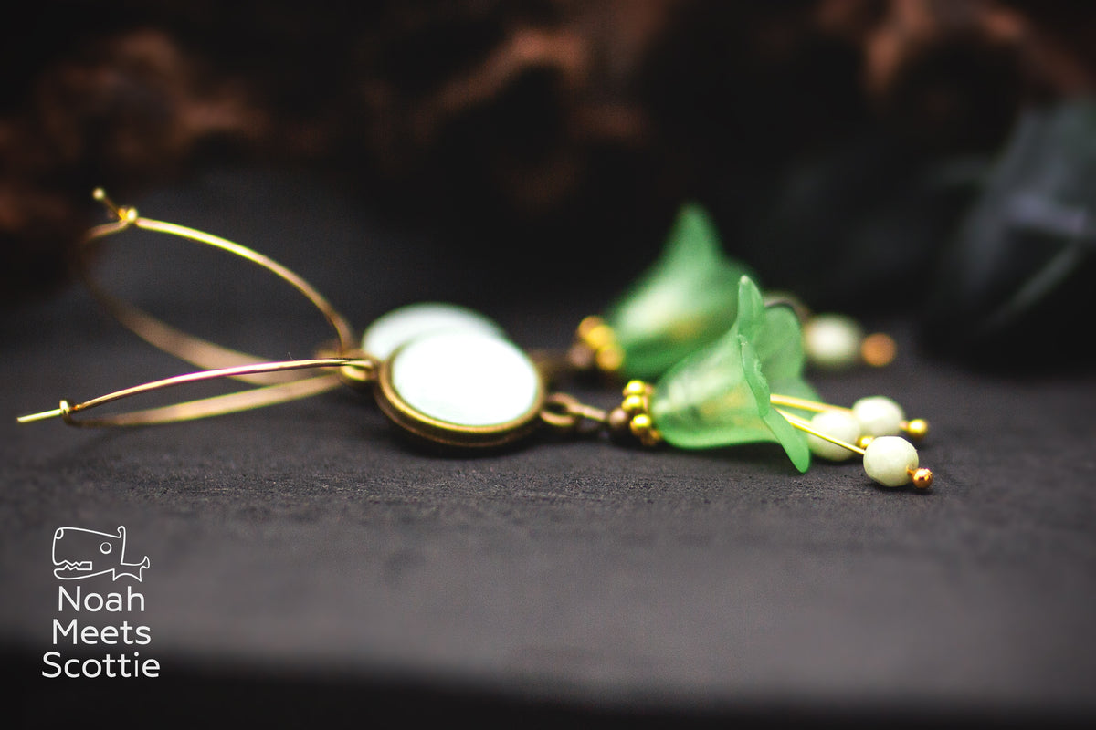 Florale Statement Ohrringe in Mint- und Lindgrün mit großer Blüte, facettierten Glasperlen und rundem Glascabochon.