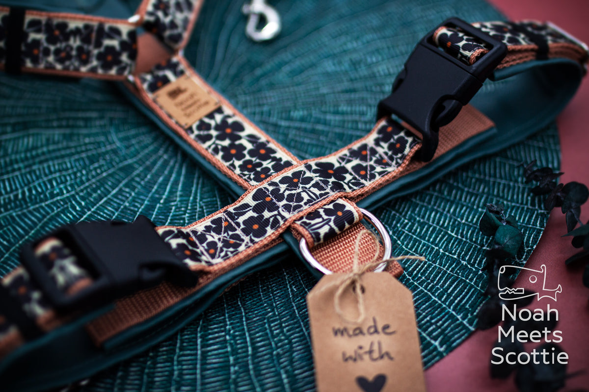 Detail des Retro-Blumenmusters mit schwarzen fünfblättrigen Blüten, kleinen orangefarbenen Mittelpunkten und hellbrauner Einfassung.
