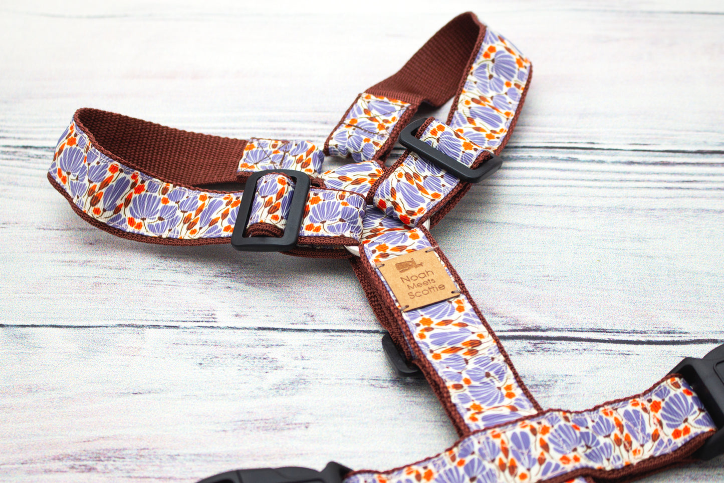 Hundegeschirr DANDELIGHT mit zartem Pusteblumenmuster in Braun, Lila und Orange auf hellem Untergrund, naturinspiriertes Design auf braunem Gurtband für moderne Hundeaccessoires.