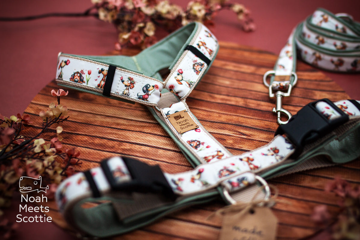 Detailansicht des Hundegeschirrs mit unterschiedlichen illustrierten Hunden, roten und rosa Blumen und kleinen Tulpen.
