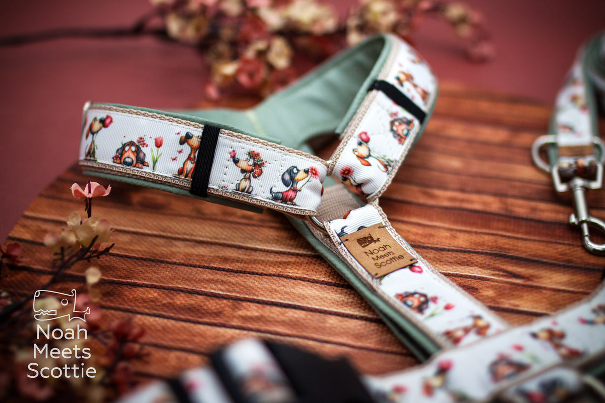 Hundegeschirr mit verschiedenen kleinen Hundeillustrationen zwischen Blumen und Tulpen und salbeigrünem Kunstlederfutter.