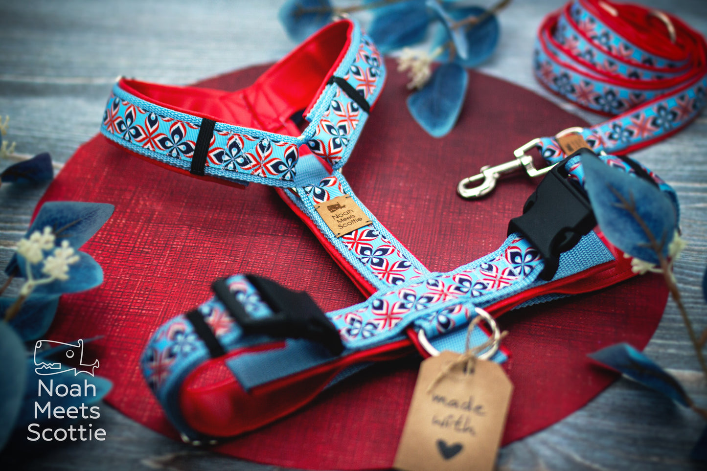 Verstellbares Hundegeschirr Mads mit hellblauem Gurtband und kräftig roter Kunstlederpolsterung.