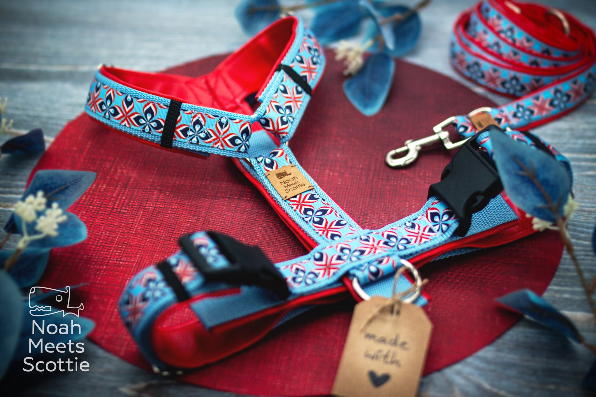 Verstellbares Hundegeschirr Mads mit hellblauem Gurtband und kräftig roter Kunstlederpolsterung.
