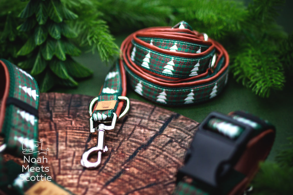 Hundegeschirr für Weihnachten mit weißen Tannenbäumen, schwarzen Kunststoff-Steckverschlüssen und silberfarbenen Metallbeschlägen.