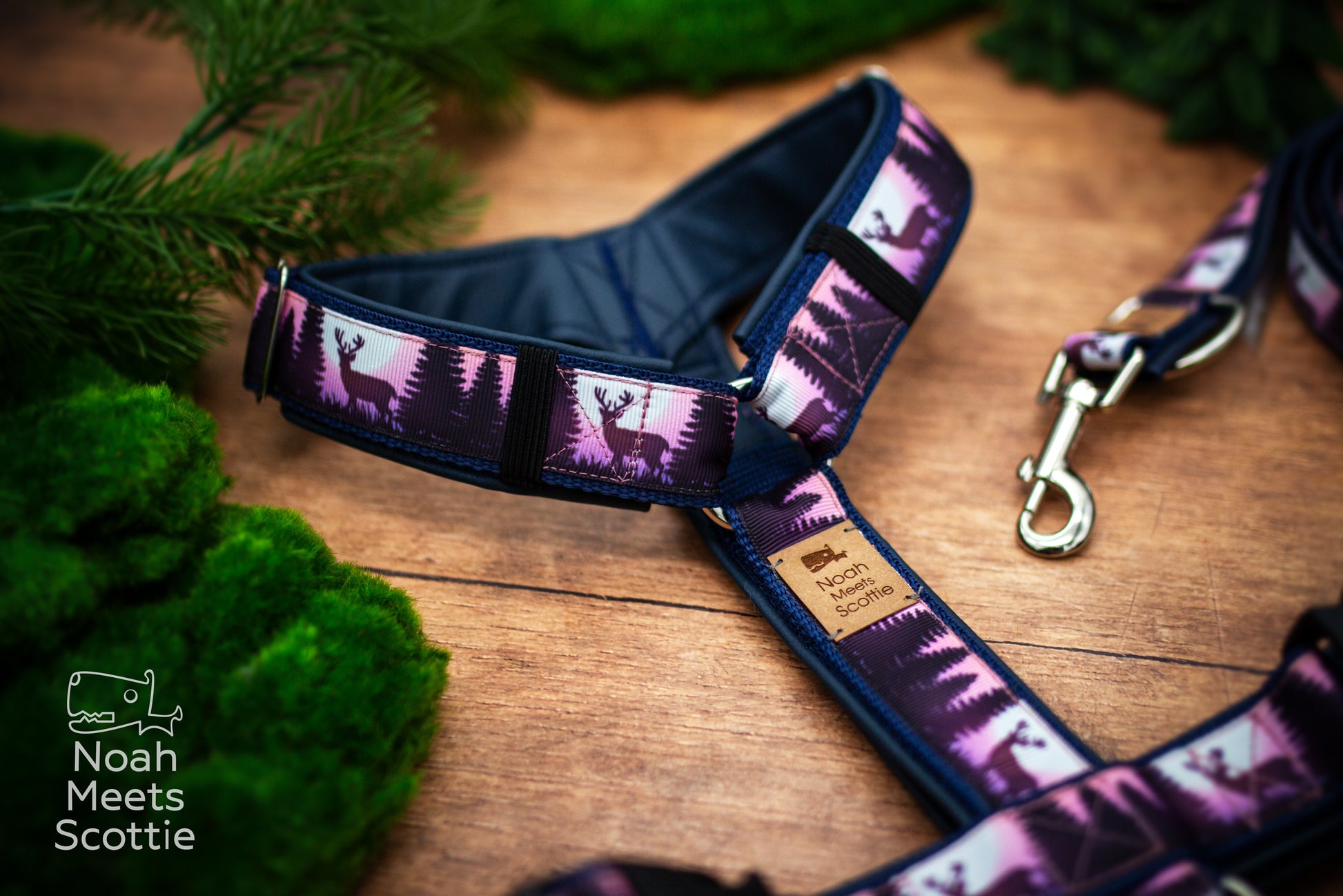 Nahaufnahme des Waldmotivs mit Hirsch zwischen dunklen Tannen und violett-rosafarbenem Himmel in der Dämmerung.