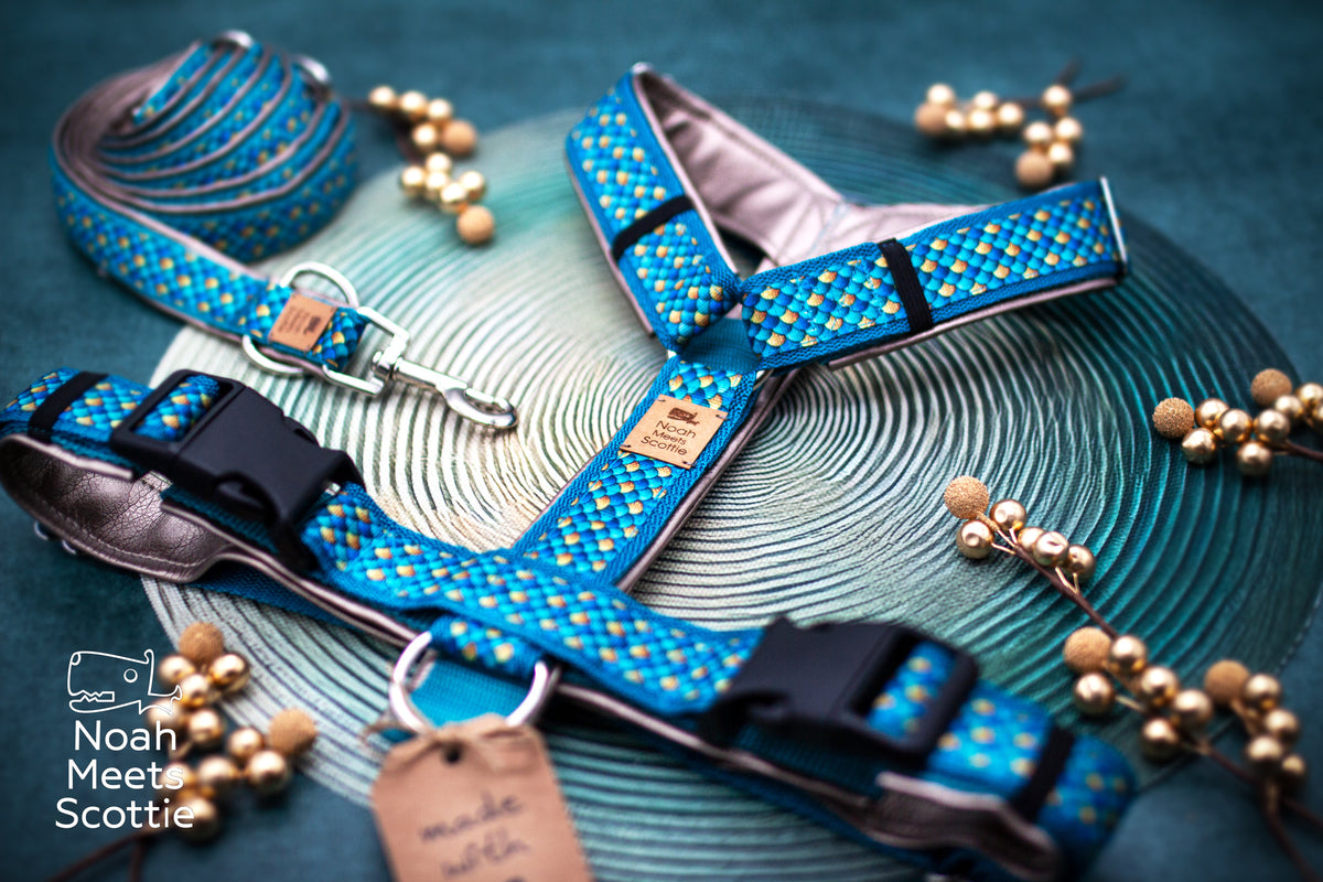 Hundegeschirr Poseidon mit Schuppenmuster in Türkis, Blau und Gold und goldfarbener Kunstlederpolsterung.