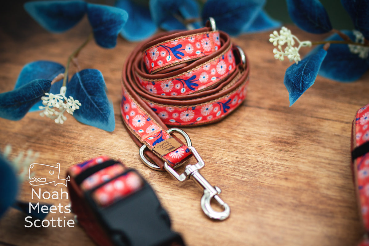 Nahaufnahme des korallfarbenen Blumenmusters mit zahlreichen kleinen weißen Blütenformen und dunkelblauen Pflanzenmotiven im nostalgischen Retro-Stil.