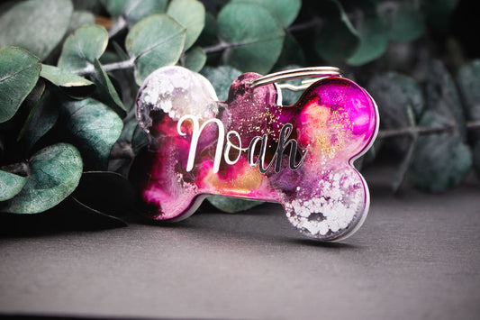 Hundemarke im Knochen-Design mit Farbverlauf in Lila, Weiß, Grau und Gold, Resin, veredelt mit Glitzer