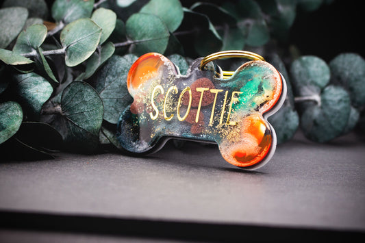 Hundemarke im Knochen-Design mit kräftigem Farbverlauf in Orange, Schwarz und Grün, Resin, veredelt mit Glitzer