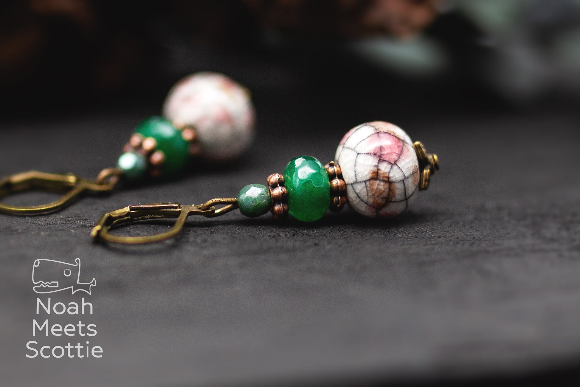 Keramikschmuck mit weißer Keramikperle, grünen Glasperlen und bronzefarbenen Details.