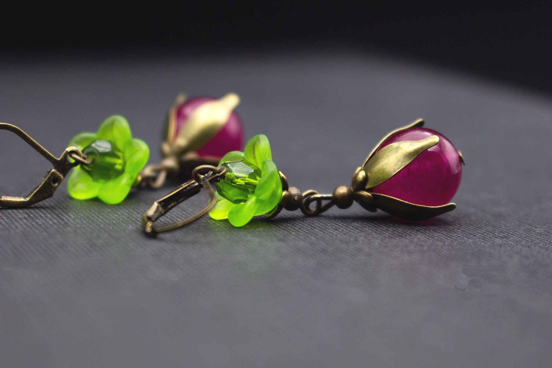 Seitliche Ansicht von Ohrringen mit Fuchsia-Perlen und grünen Blüten