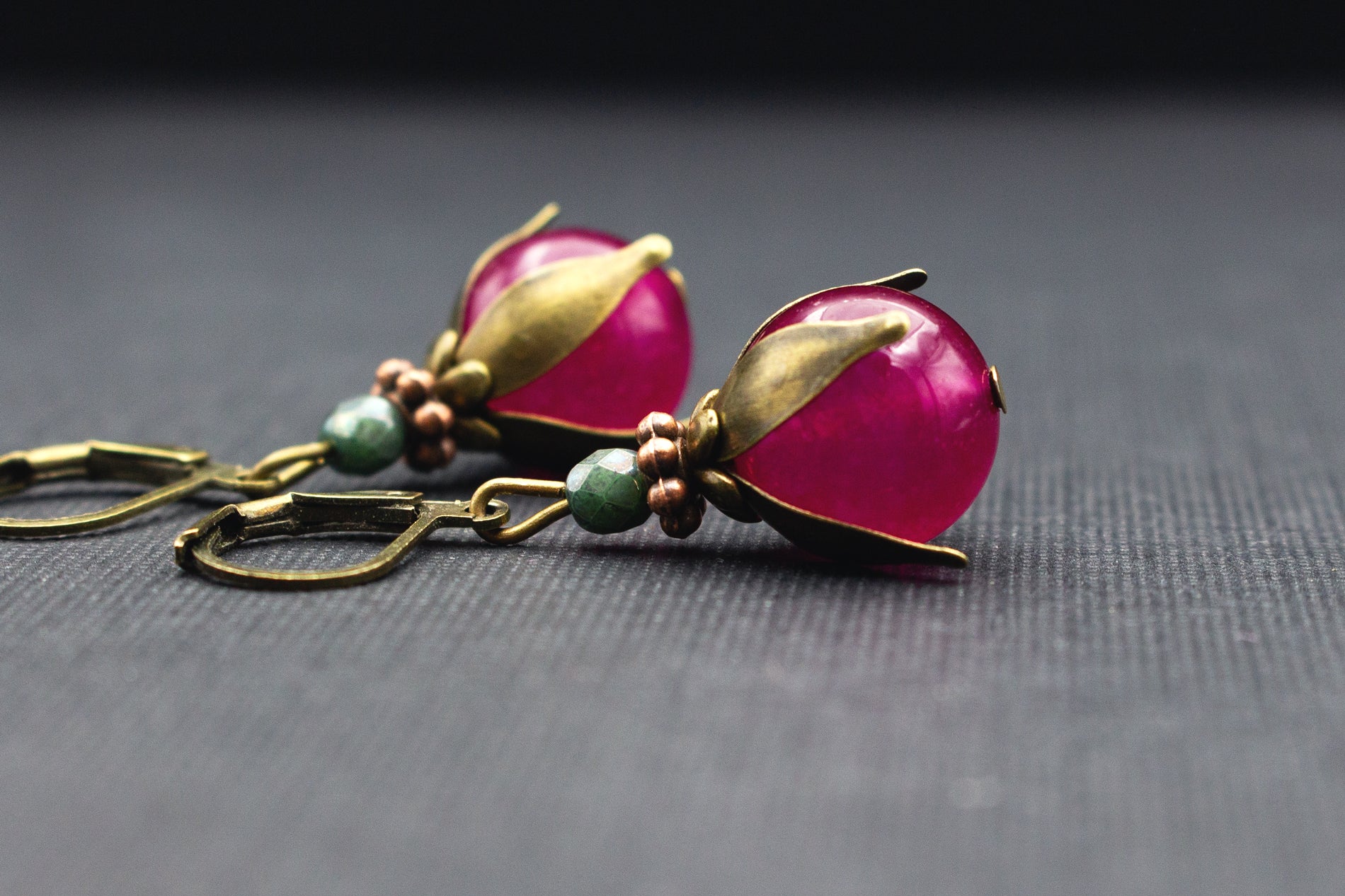Ohrringe mit Glasperlen in Fuchsia-Pink und Grün, filigrane Blütenfassung und Metallelemente in Antik-Bronze