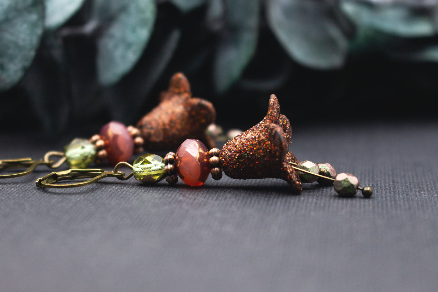 Ohrringe mit braun glitzernden Blüten, Glasperlen in Rosé-Rot und Lindgrün sowie Metallelementen in Antik-Bronze