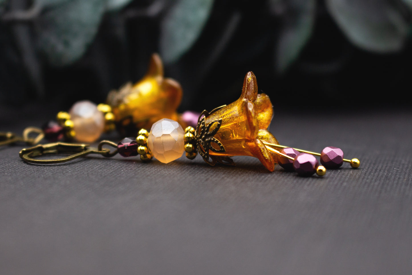 Ohrringe aus Glas und Acryl mit honiggelber Glitzerblüte, Rosé-Perlen und warmen Metalltönen