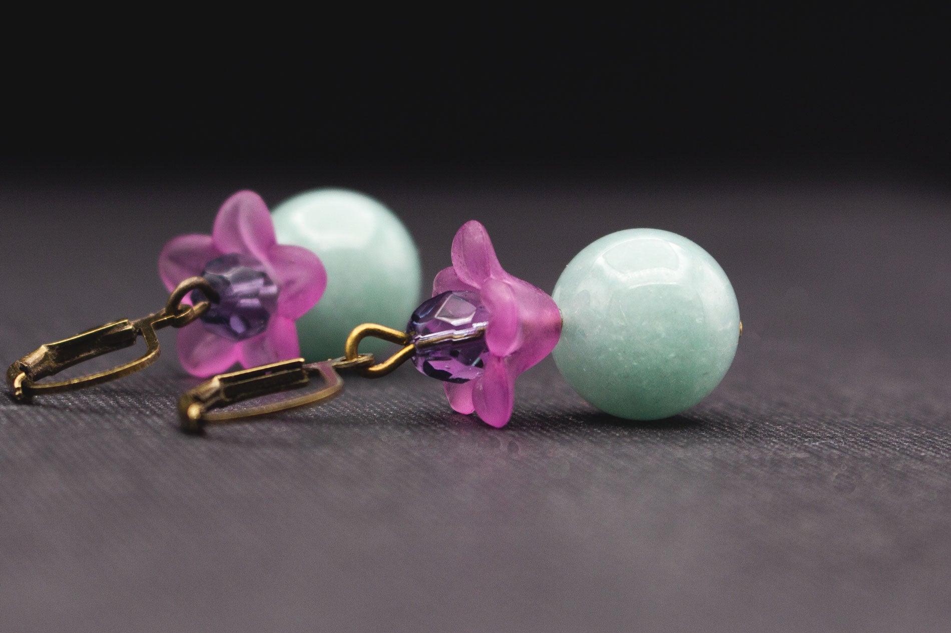 Detailansicht elegante Ohrringe mit hellblauen Glasperlen und violetten Blüten
