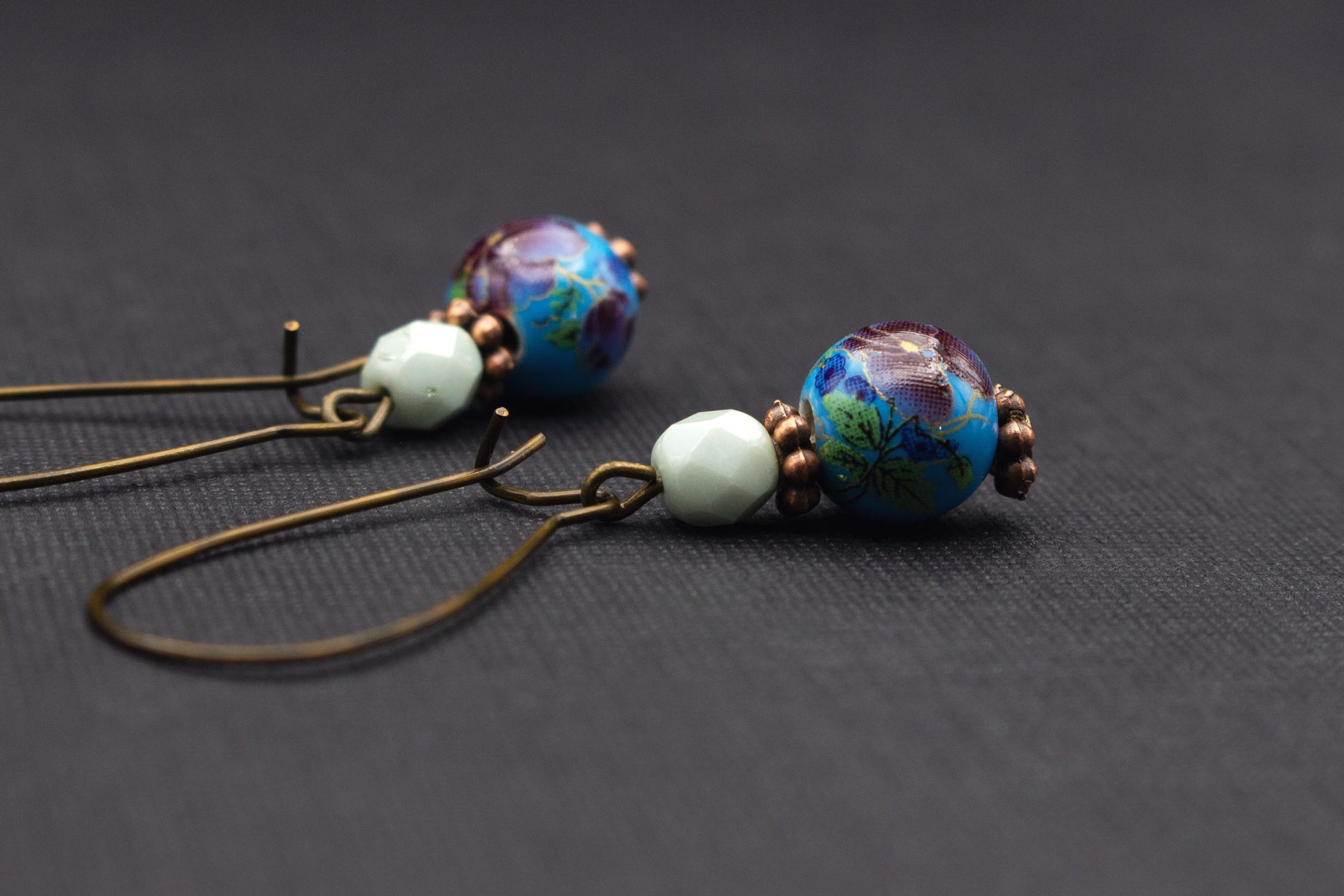 Seitliche Ansicht der Ohrringe mit Kirschblütenmotiv in Blau, Lila und Mint