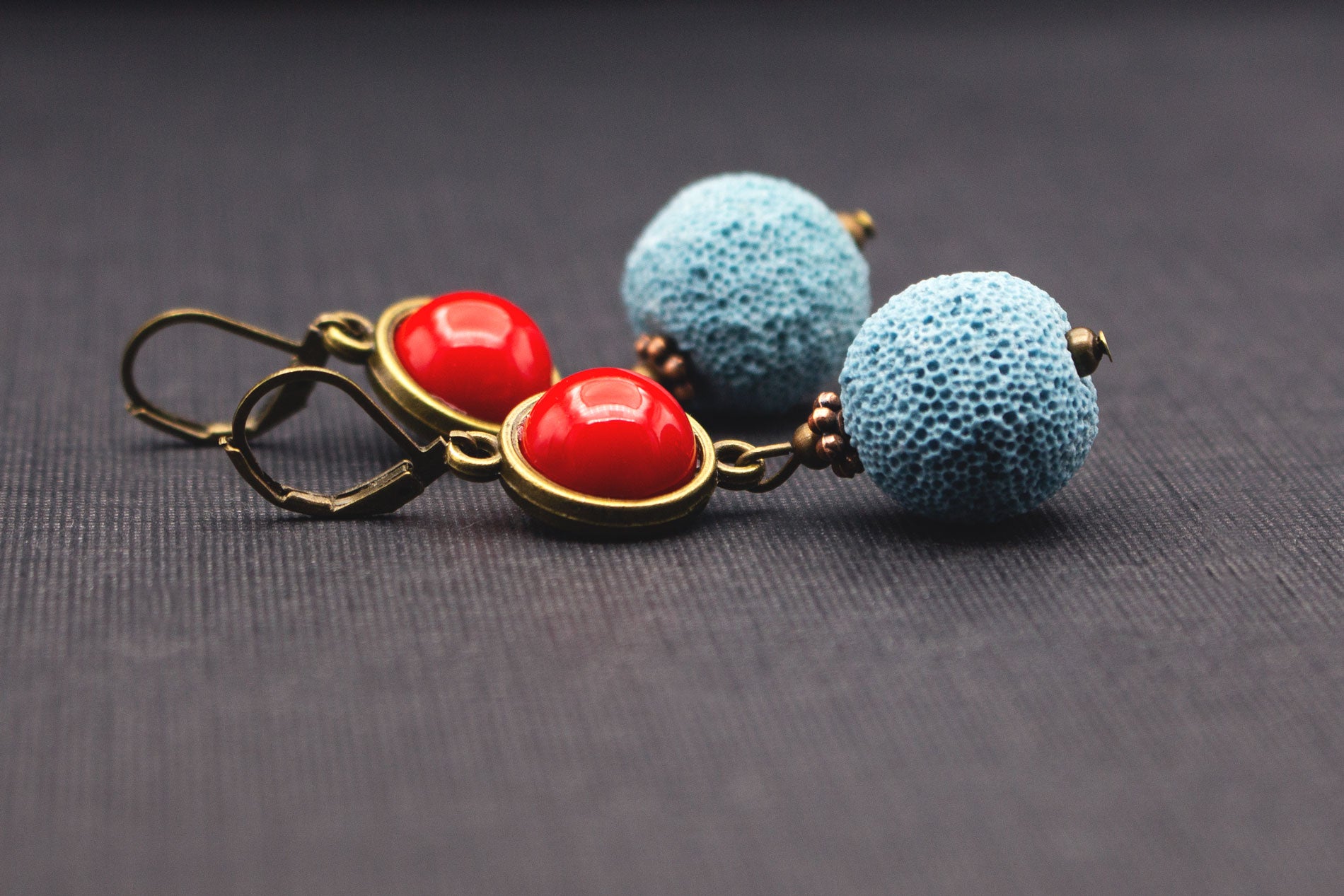 Detailansicht Statement-Ohrringe mit Lavaperlen in Hellblau und roten Cabochons