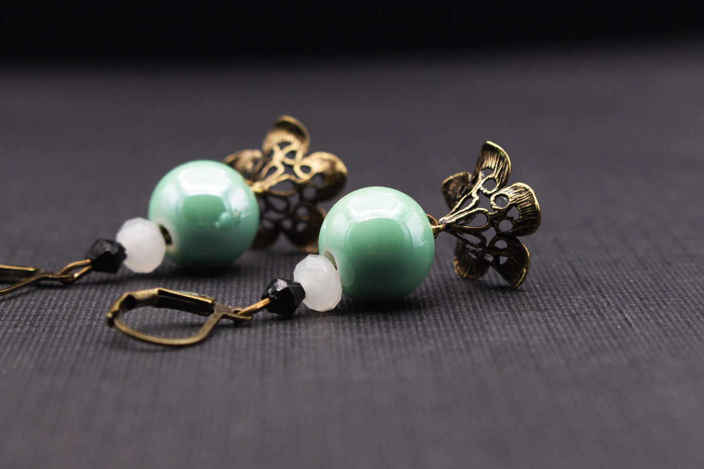 Detailansicht elegante Ohrringe mit mintfarbenen Perlen und Vintage-Blättern