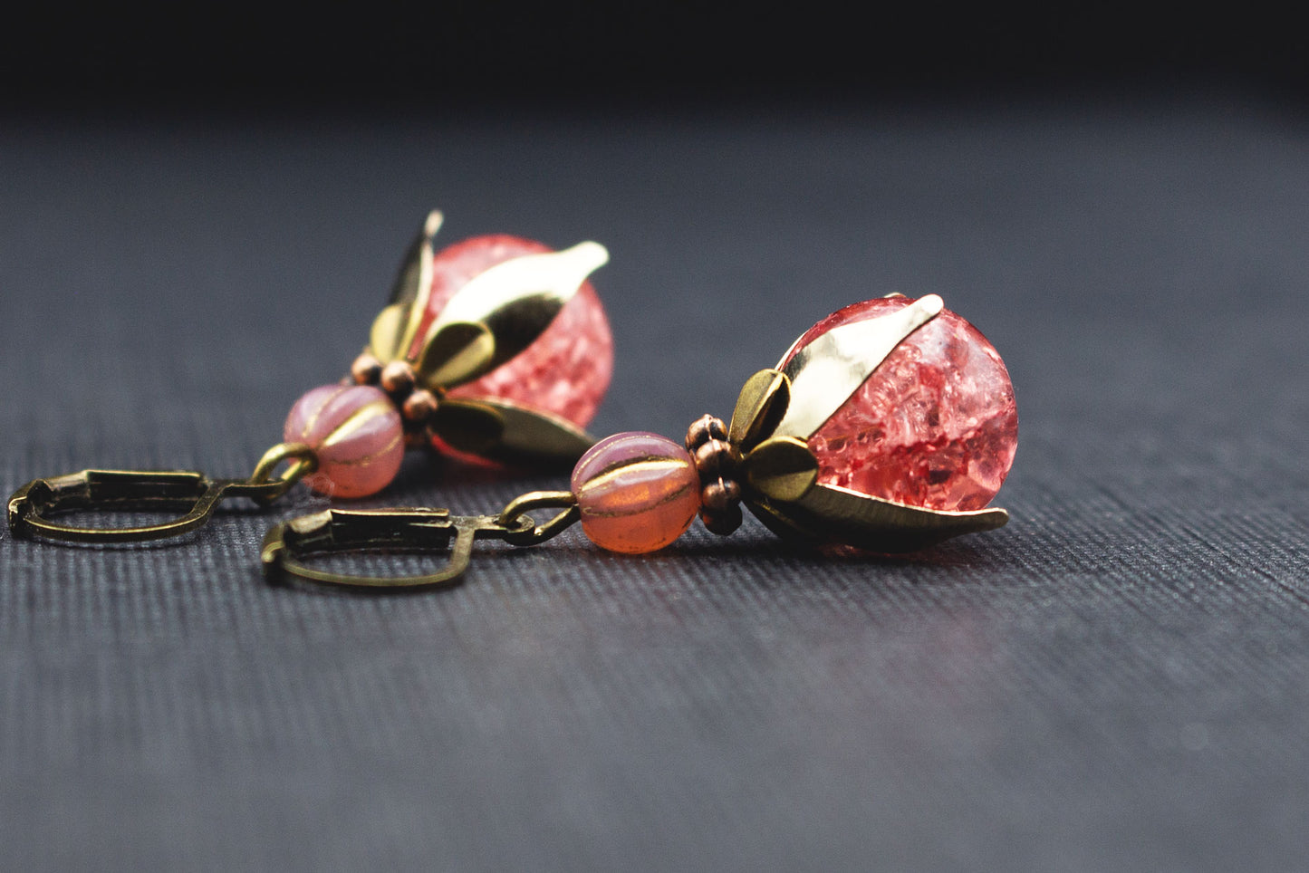 Seitenansicht von Ohrringen mit rosa Crackle-Glasperlen und goldfarbenen Perlenkappen