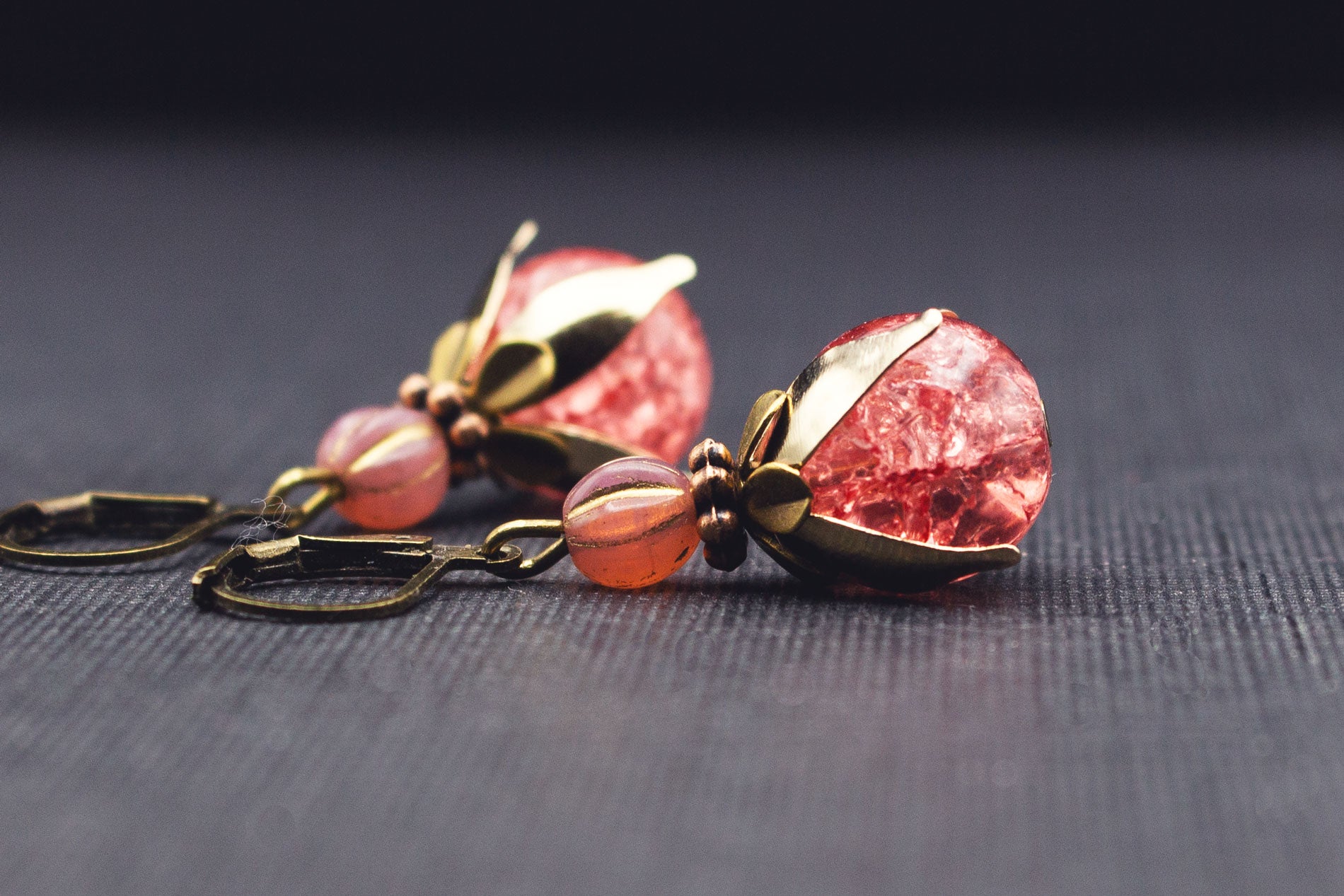 Detailaufnahme von Ohrringen mit rosa Crackle-Glasperlen und Kürbisperlen in Rosa mit goldenen Streifen
