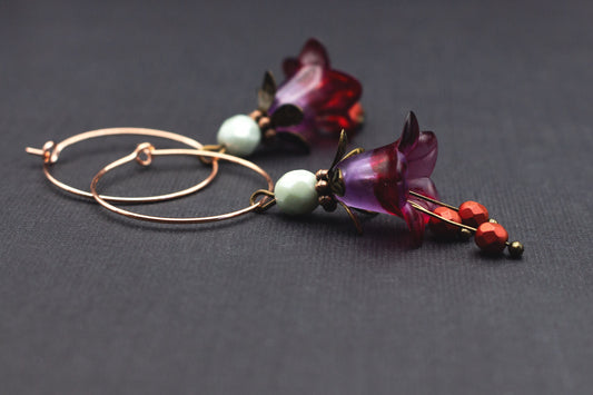 Roségoldfarbene Creolen mit lila-roten Acrylblüten und Glasperlen in Metallic-Rot und Mint