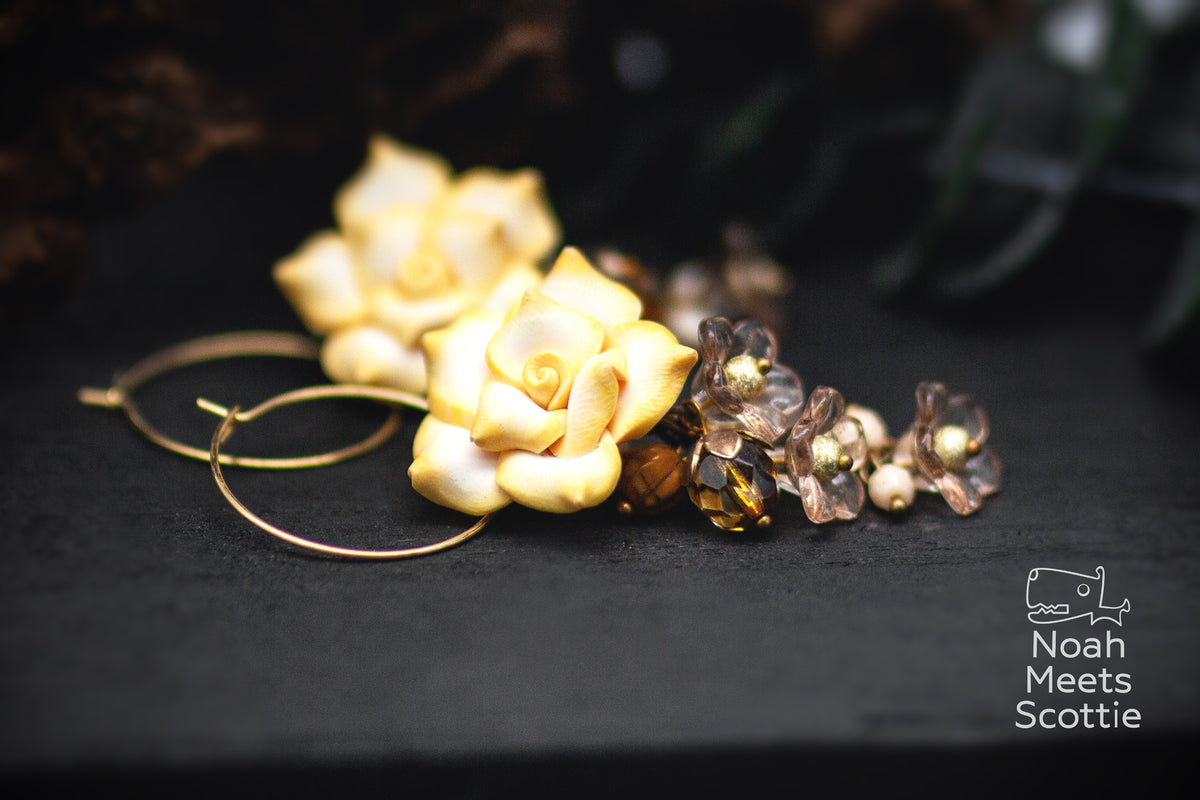 Rosen Creolen mit vanillegelben Rosen, bernsteinfarbenen Perlen, kleinen taupe-grauen Blüten und goldfarbenen Details.