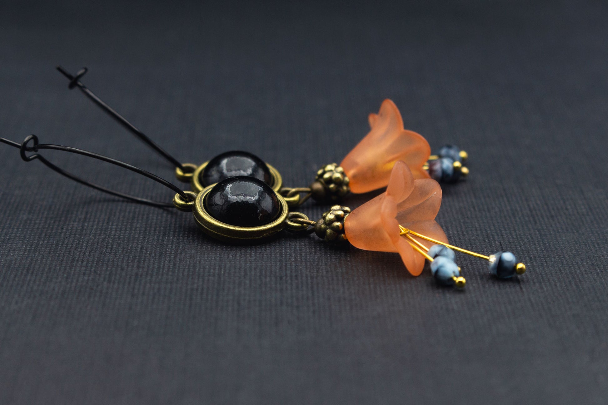 Schwarze Creolen mit orangefarbenen Acrylblüten und schwarzem Cabochon