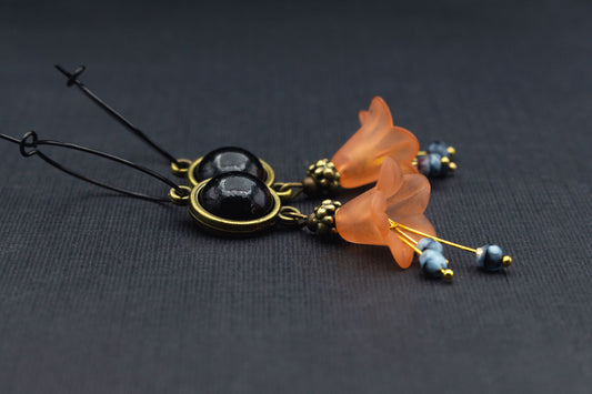 Schwarze Creolen mit orangefarbenen Acrylblüten und schwarzem Cabochon