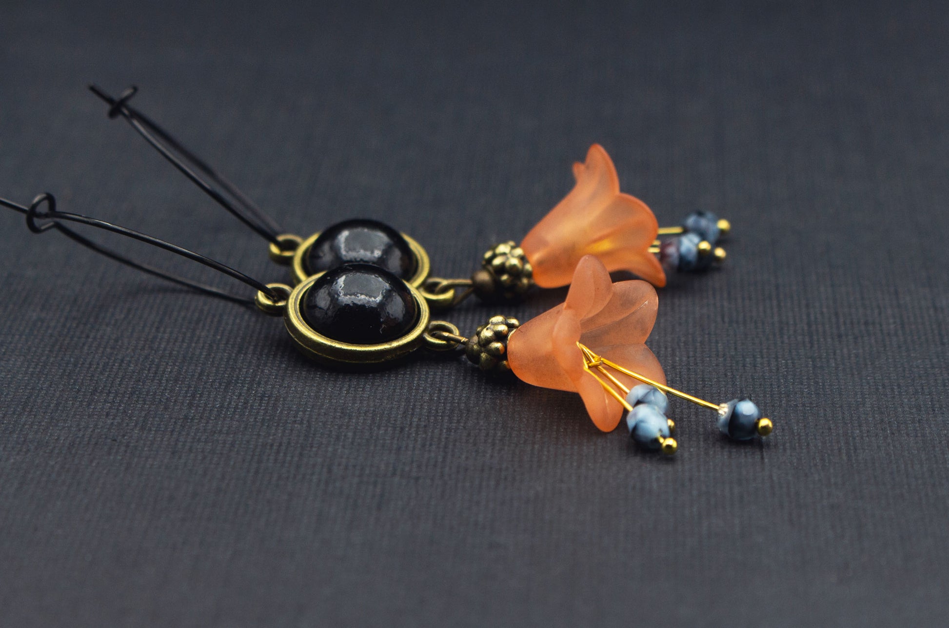 Seitenansicht schwarze Creolen mit orangefarbenen Acrylblüten