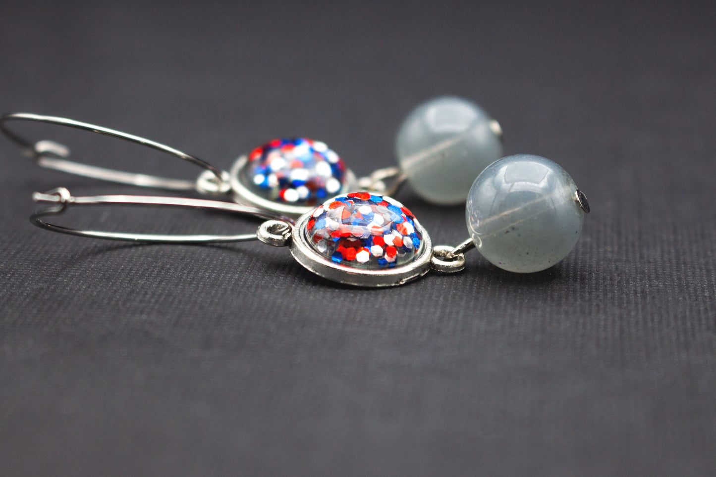 Silberfarbene Creolen mit Cabochon-Perlen in Rot, Blau und Silber sowie Glasperlen in Rauchgrau